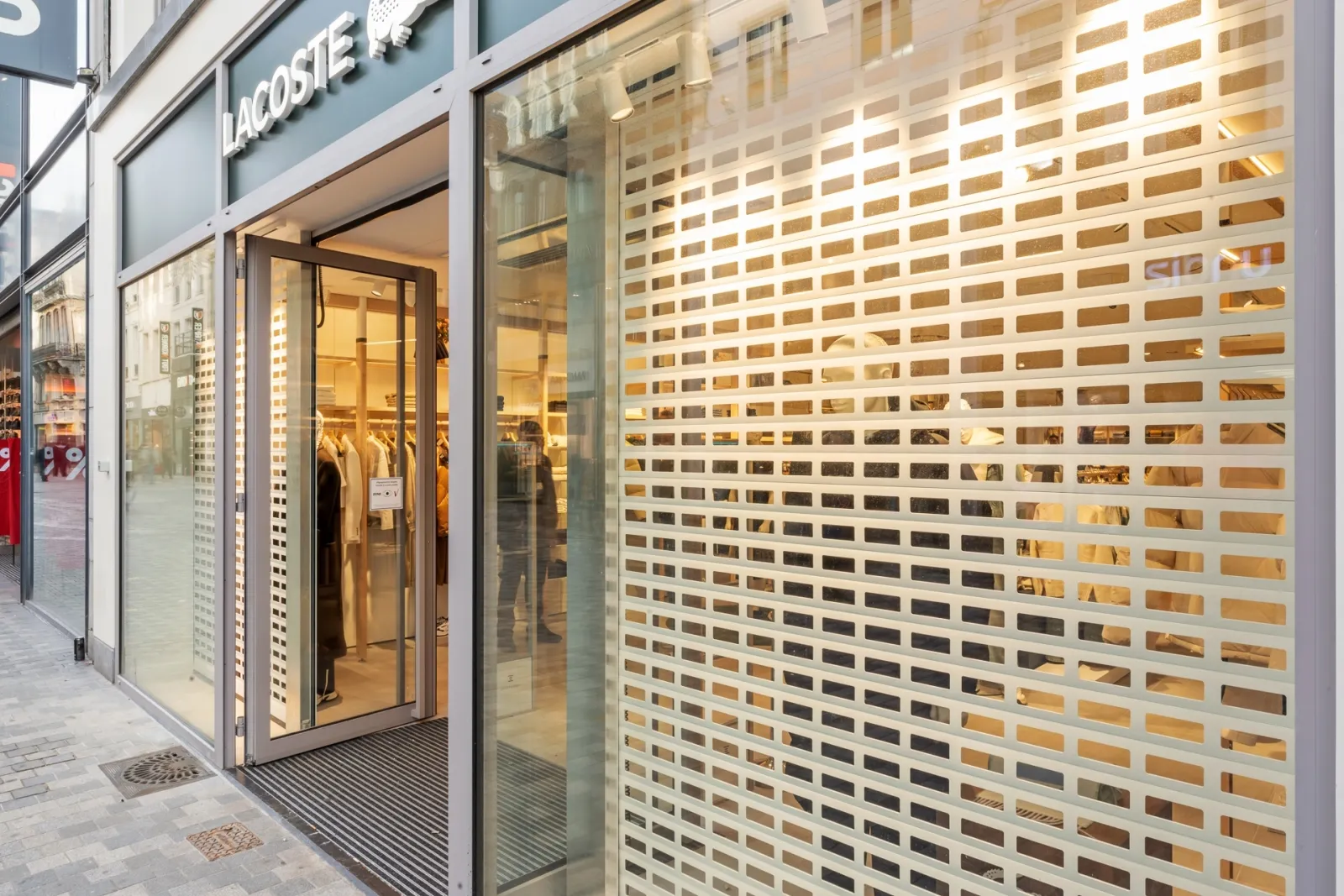 Grilles roulantes blanches pour Lacoste au cœur de Bruxelles